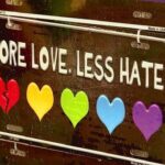 There is a saying at the top: “More Love. Less Hate.” Underneath are five different colored hearts. The first heart is broken.