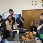 Students gathers around a table talking and taking free donuts